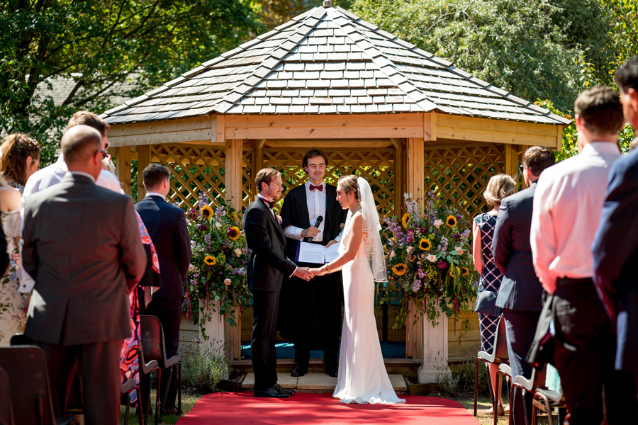 Couple exchanging vows at Gonville and Caius College outdoor wedding ceremony