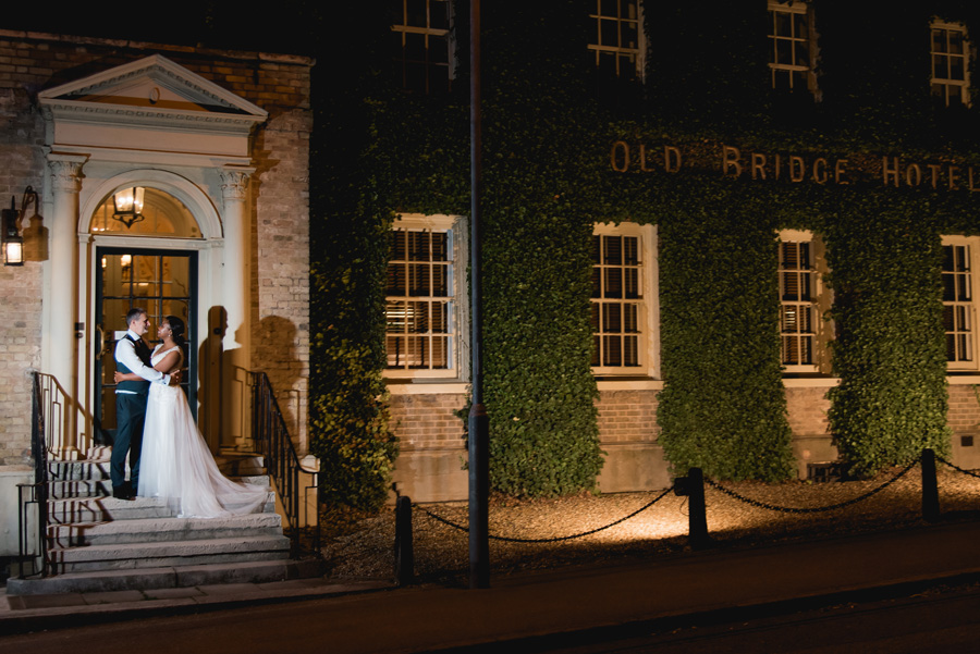 Couple standing on the steps outside The Old Bridge Hotel in Huntingdon during an evening wedding portrait