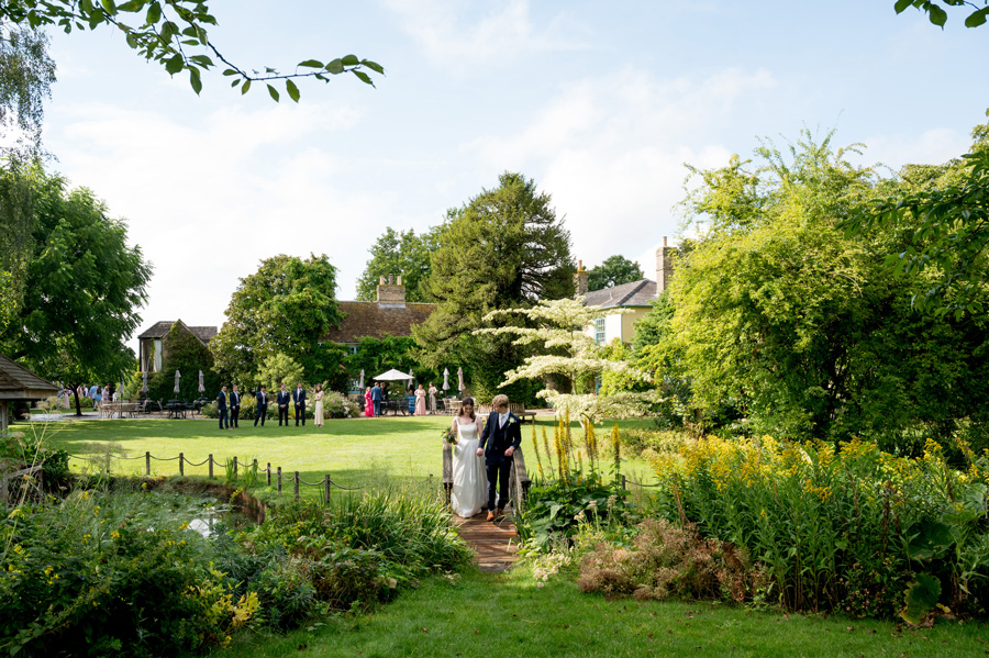 Couple on wooden bridge in the gardens at South Farm wedding venue