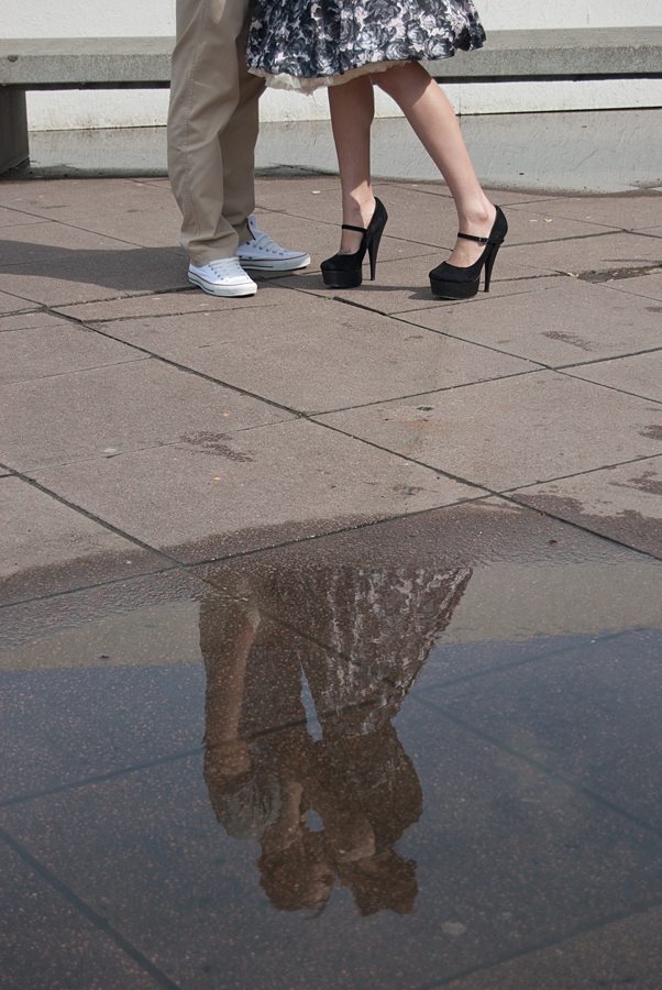 Reflection of couple in puddle kissing