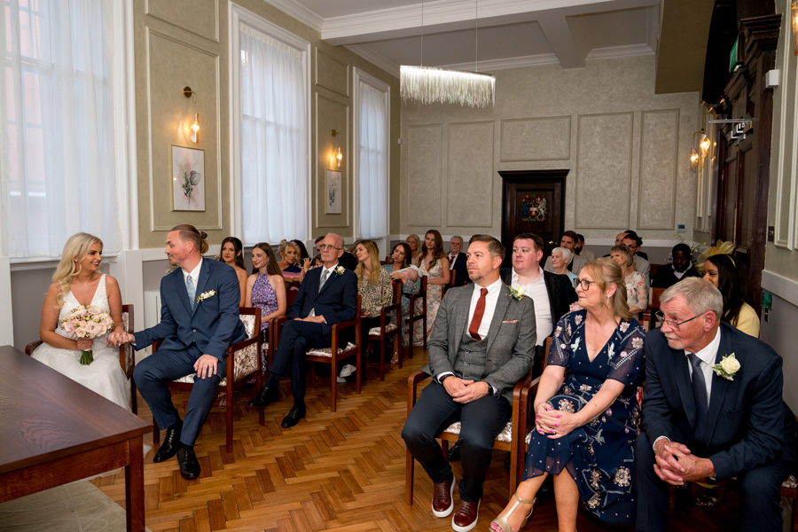 Wedding ceremony inside a Town Hall with guests seated