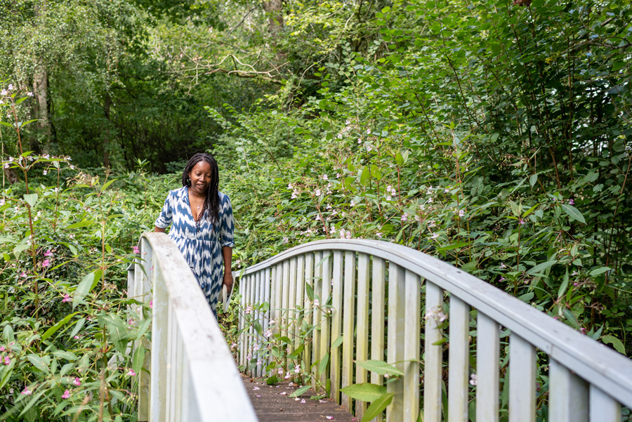 Woman in blue and white dress walking over bridge