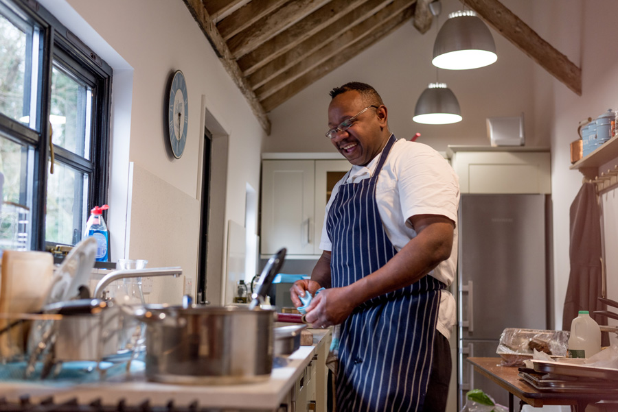 Chef cleaning up in kitchen and laughing