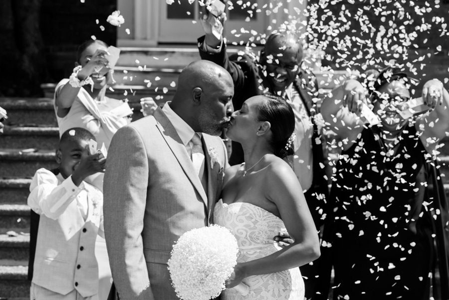 Couple kissing while being showered in confetti