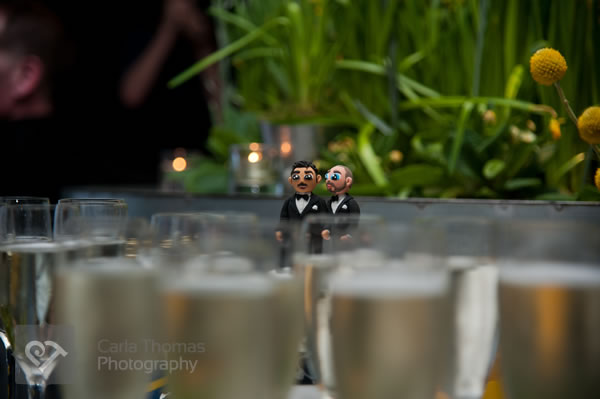Cake toppers peeping over champagne flutes