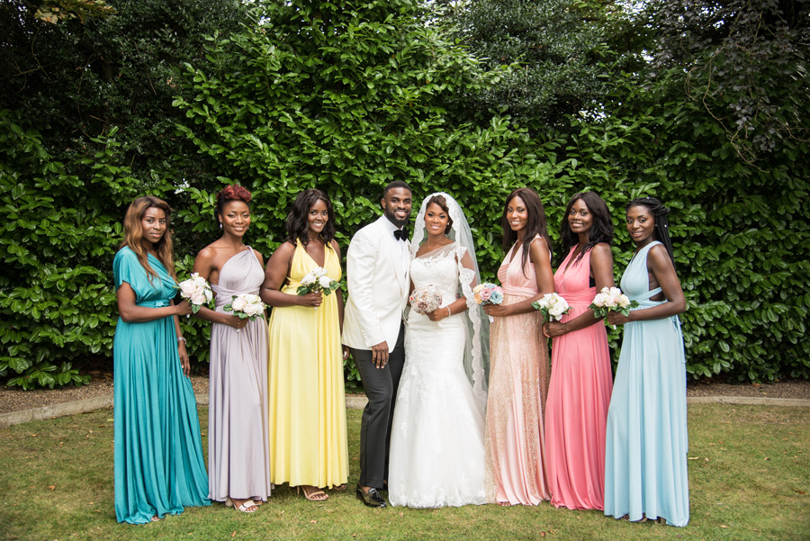 Bride and groom with bridesmaids in different coloured dresses