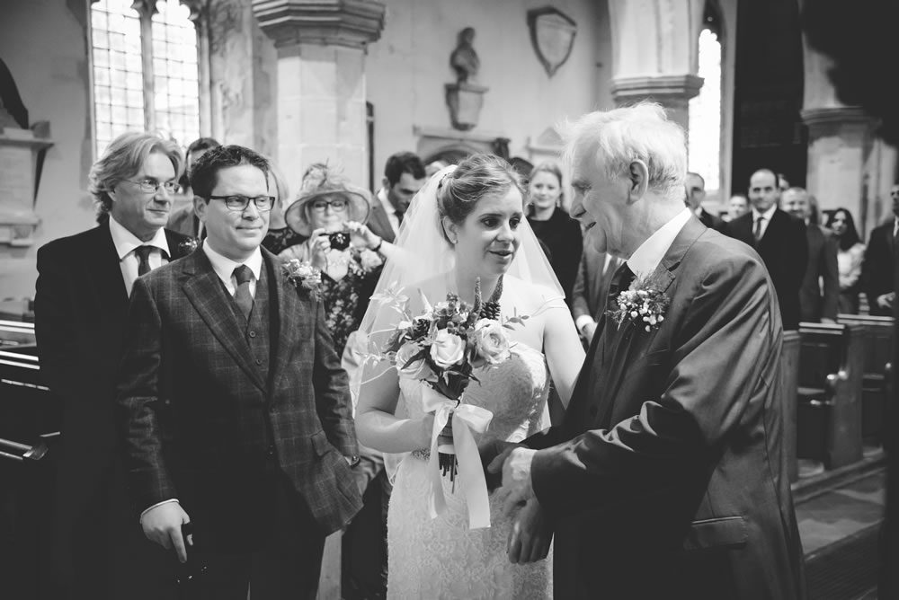 B&W of bride with father at altar