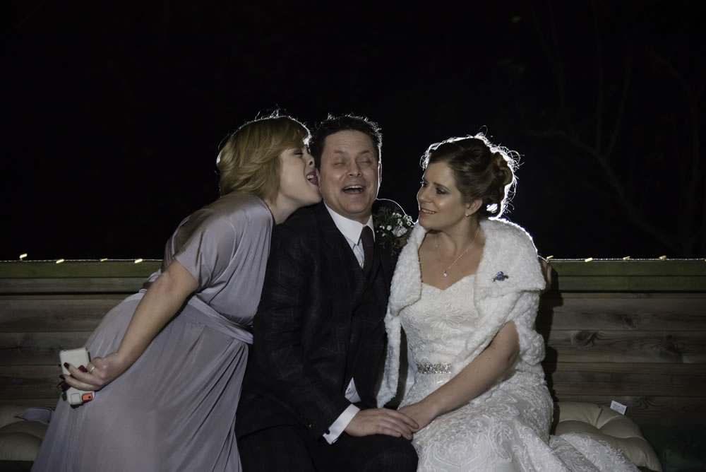 Bridesmaid kissing groom