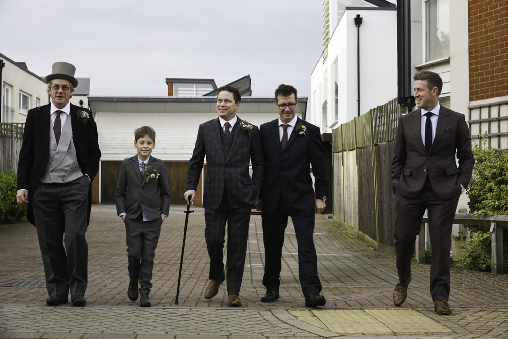 Groom with wedding party walking down the road