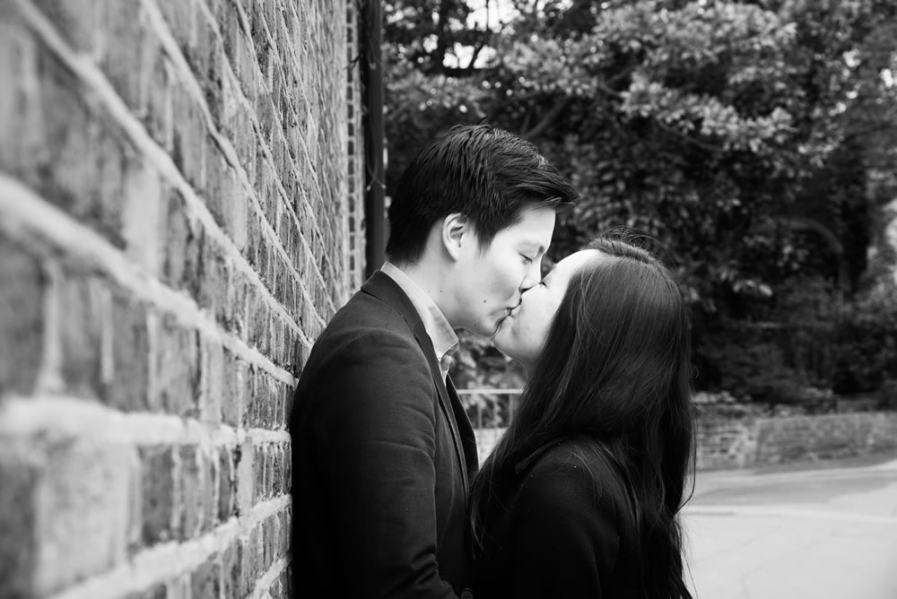 Couple kissing while leaning against wall