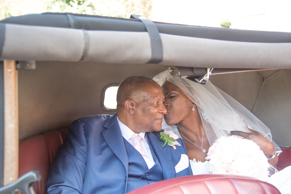 Bride kissing her father in the back of the wedding car