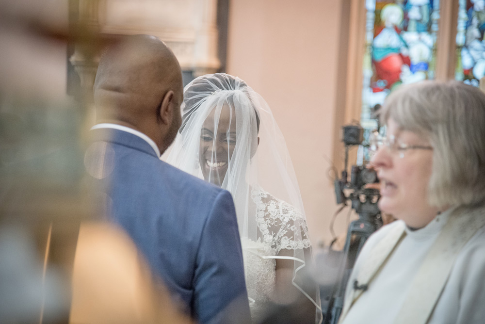 Bride smiling at groom at altar