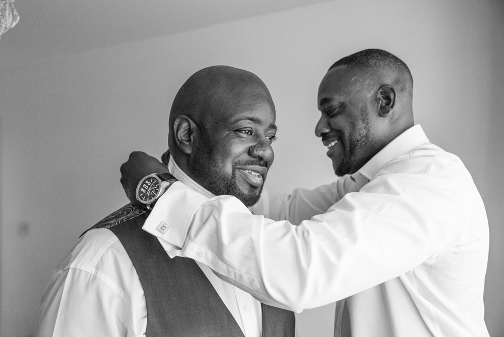 best man fixing groom&rsquo;s collar