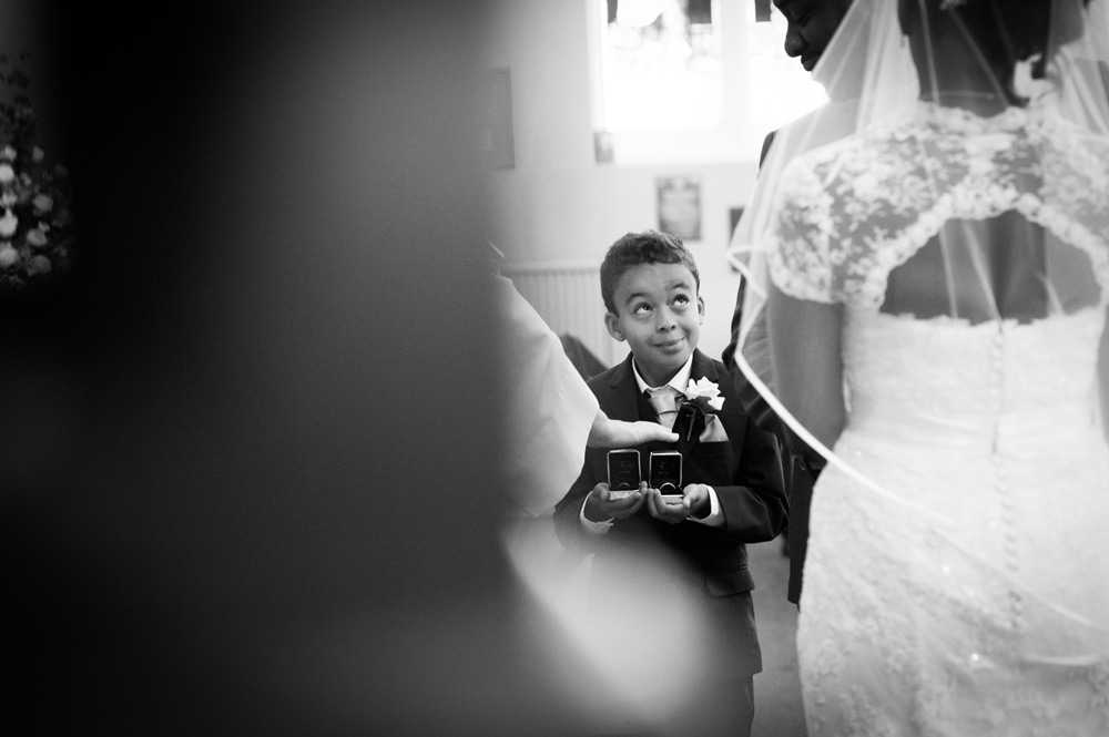 Page boy with rings smiling up at groom