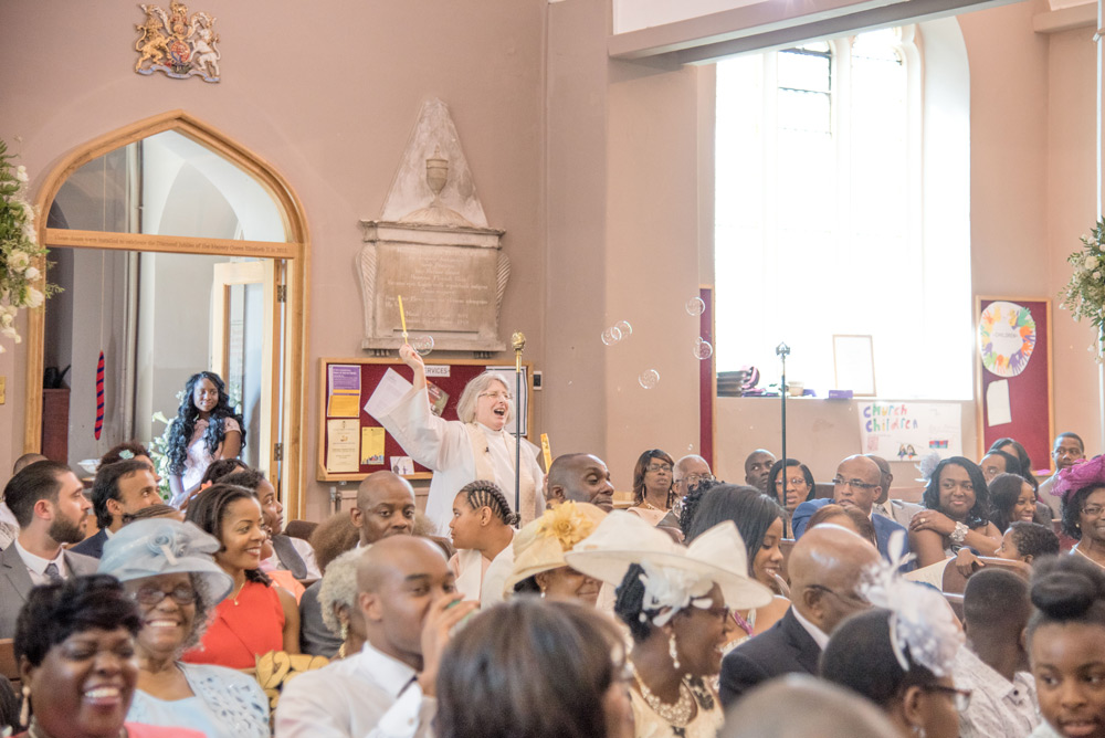 Vicar walking through congregation with bubble wand