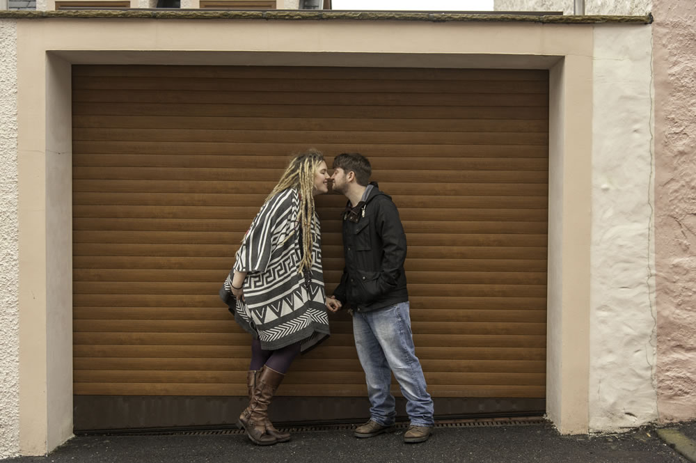 Couple kissing in front of garage doors