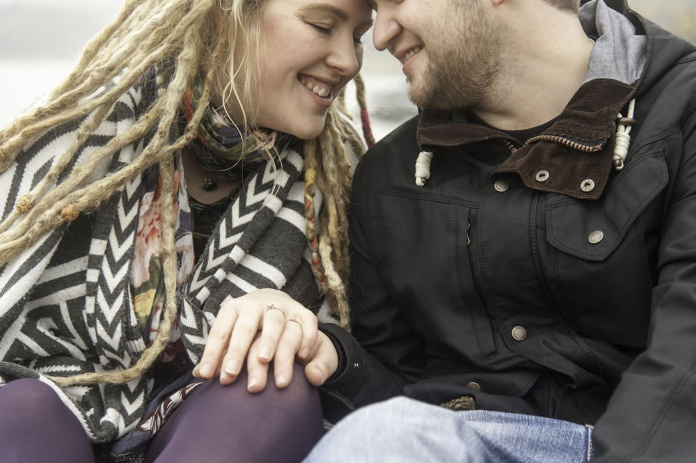Couple sat holding hands with foreheads touching