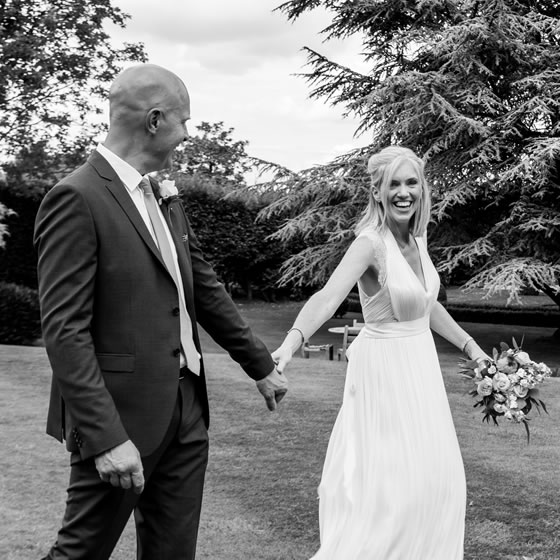 Groom and bride walking in grass