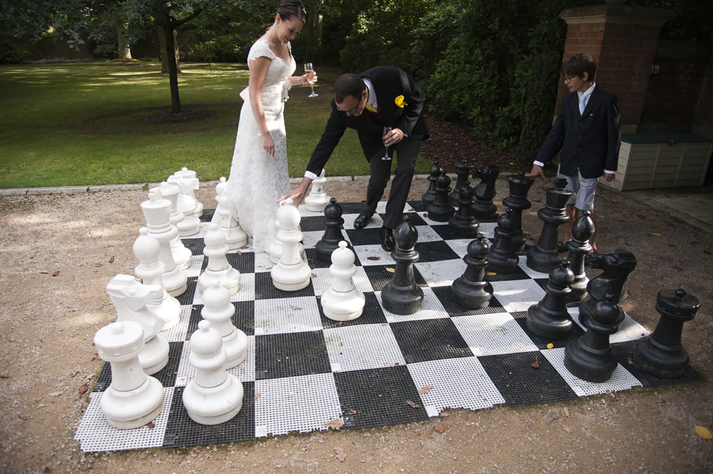 Bride and groom playing chess in the garden